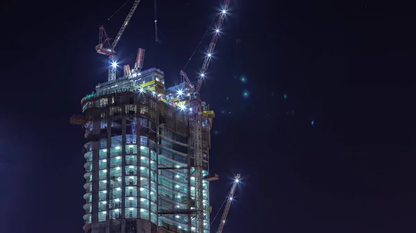 Dźwigi Pracujące Nad Dużą Przestrzenią Ograniczającą Prace Nowego Wieżowca Nocy — Zdjęcie stockowe