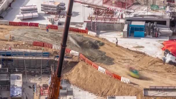 Gru e bulldozer che lavorano nel cantiere del nuovo grattacielo timelapse aerea. — Video Stock