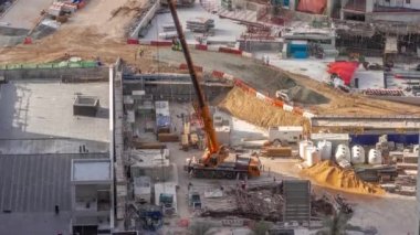 Vinçler ve buldozerler yeni gökdelen hava zaman çizelgesinin şantiyesinde çalışıyorlar..