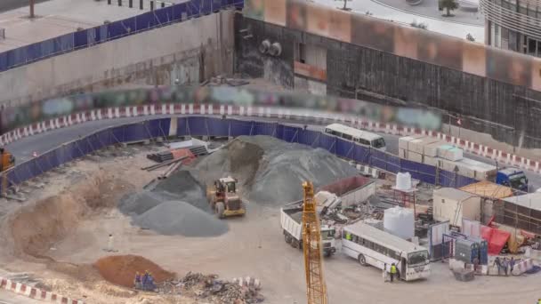 Grues et bulldozers travaillant sur le chantier de construction d'un nouveau gratte-ciel timelapse aérienne. — Video