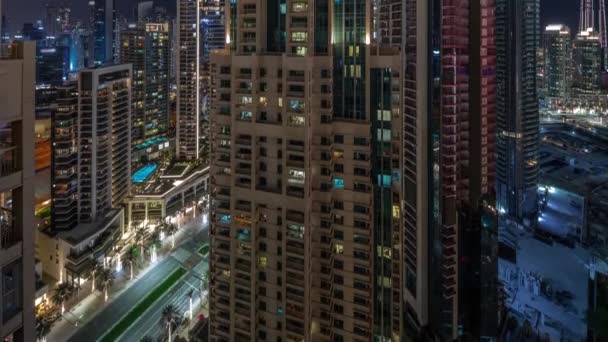 Воздушный городской пейзаж ночного времени с освещенной архитектурой центра Дубая. — стоковое видео