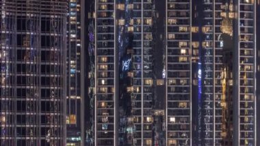 Apartman binasındaki parlayan pencerelerin gece görüntüsü.