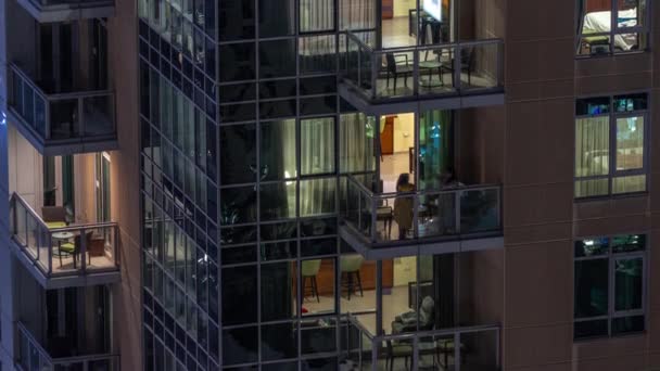 Nachtzicht van gloeiende panoramische ramen in appartementengebouw timelapse. — Stockvideo