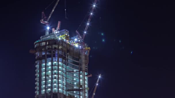 Γερανοί που εργάζονται σε μεγάλα εργοτάξια του νέου ουρανοξύστη νύχτα timelapse — Αρχείο Βίντεο