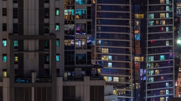 Ventanas de un rascacielos acristalado brillan por la noche con luces de la ciudad reflejo timelapse aéreo. — Vídeos de Stock