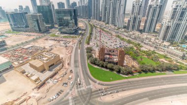 Business Bay havacılık panoramik zaman diliminde modern kuleleri olan Bay Avenue, Dubai, BAE. Büyük otoparklı gökdelenler ve hızlı hareket eden gölgeler.