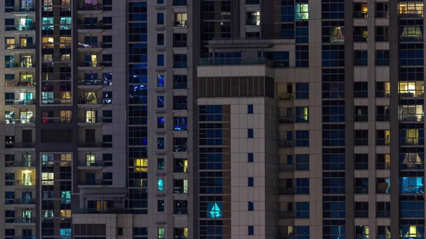 一座玻璃摩天大楼的公寓窗户闪烁着城市灯光反射着空中时间的流逝 蓝光照明塔 — 图库照片