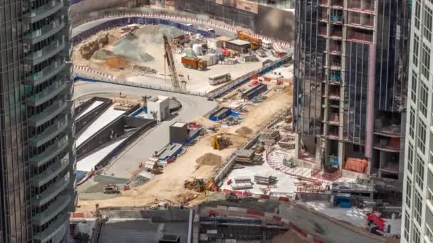 新しい超高層ビルの空中タイムラプスの建設現場で働くクレーンやブルドーザー. — ストック動画