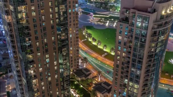 Parco con prato verde vicino fontane timelapse notte aerea. Torri intorno al lago artificiale nel centro di Dubai. — Video Stock