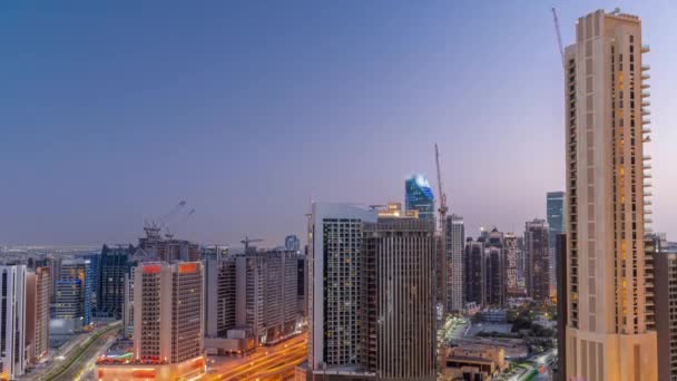 Rascacielos en Business Bay en Dubái día aéreo a noche timelapse, Emiratos Árabes Unidos — Vídeos de Stock