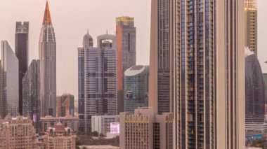Şeyh Zayed Yolu ve DIFC bölgesi çevresindeki yüksek binaların sıraları Dubai 'de günden geceye