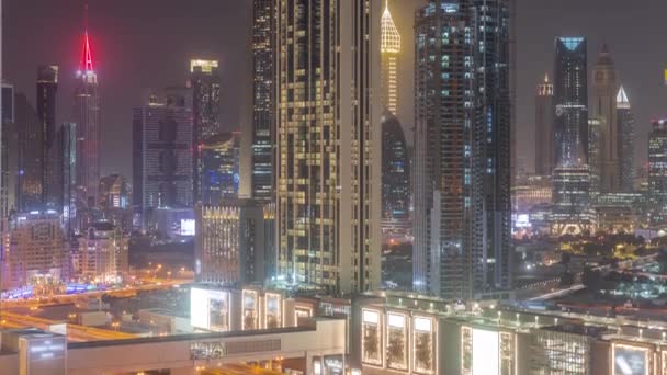 Wiersz wysokich budynków wokół Sheikh Zayed Road i lotniczej nocy DIFC w Dubaju — Wideo stockowe