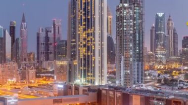 Şeyh Zayed Yolu ve DIFC bölgesi çevresindeki yüksek binaların panoraması Dubai 'deki gece gündüz havacılık.