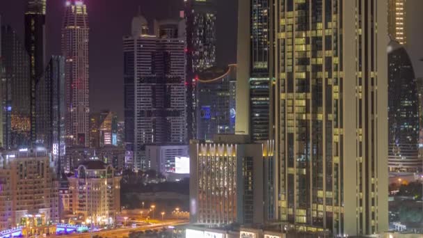 Sorban a magas épületek körül Sheikh Zayed Road és DIFC kerület légi éjszakai időeltolódás Dubai — Stock videók