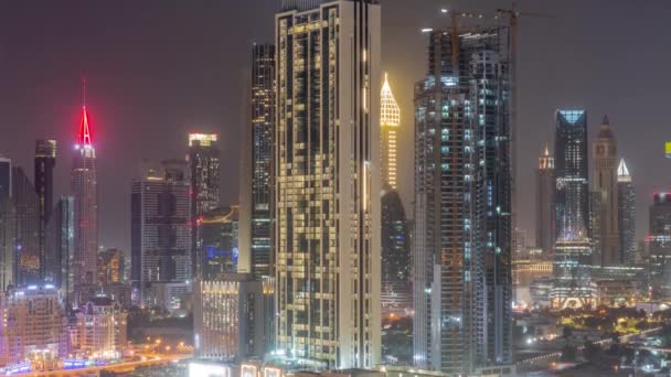 Rangée des grands bâtiments autour de Sheikh Zayed Road et DIFC district aérien toute la nuit timelapse à Dubaï — Video