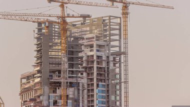 Konut kulelerinin hava zaman tüneli inşaatı. Açık gökyüzünün arka planına karşı pek çok gökdelen ve inşaat halindeki yeni binalar.