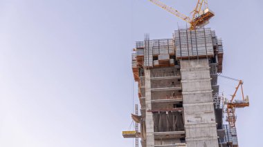 Gökdelenlerin hava zaman çizelgelerinin inşaat süreci. Açık gökyüzünün arka planına karşı pek çok gökdelen ve inşaat halindeki yeni binalar.