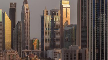 Sheikh Zayed Yolu etrafındaki yüksek binalar ve Dubai, BAE 'deki DIFC bölgesi zaman çizelgesi. Gündoğumunda cam yüzeyden yansıyan güneşli Uluslararası Finans Merkezi gökdelenleri
