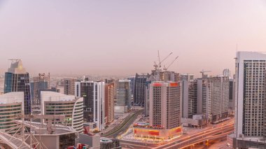 Dubai hava sahasındaki Business Bay 'deki gökdelenlerden gece geçiş zamanına kadar. Gün batımından sonra vinçleri olan yeni kulelerin kavşağı ve inşaat sahası, Birleşik Arap Emirlikleri