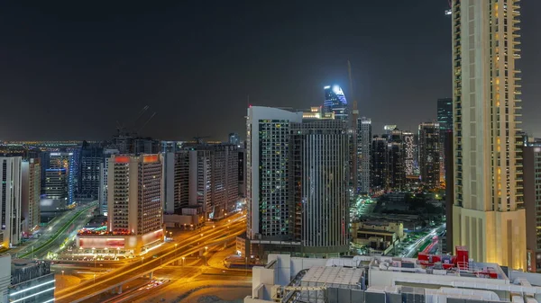 ドバイのビジネスベイでの高層ビルの夜間パノラマのタイムラプス クレーン アラブ首長国連邦との新しい塔の道路の交差点と建設現場 — ストック写真