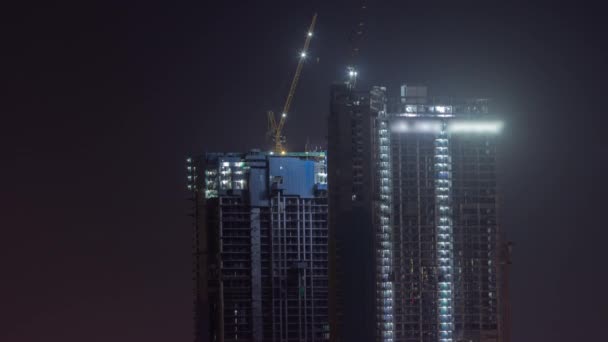 Guindastes trabalhando em obras do site de construção de novos arranha-céus noite timelapse — Vídeo de Stock