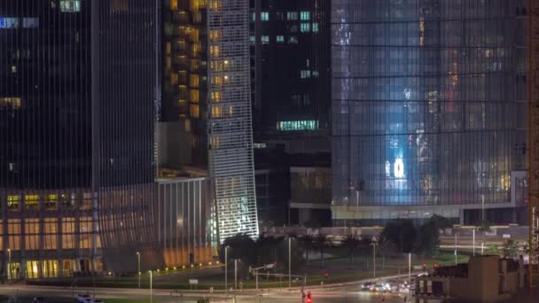 Dubai business bay district with office skyscrapers and traffic on the road intersection aerial night timelapse. — Stock Video