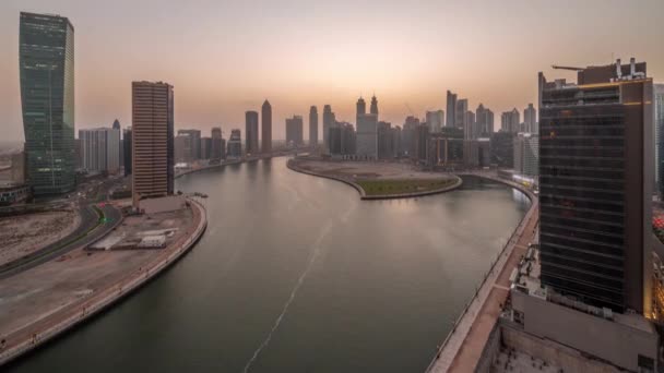 Stadsgezicht van wolkenkrabbers in Dubai Business Bay met water kanaal antenne dag tot nacht timelapse — Stockvideo