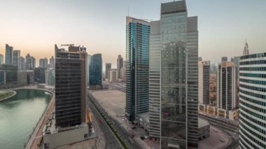 Dubai İş Koyu 'ndaki gökdelenlerin şehir manzarası. Su kanalı havası günden geceye zaman geçiyor.