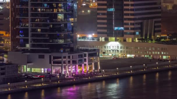 Небоскребы в деловом заливе Дубая с водным каналом в ночное время — стоковое видео