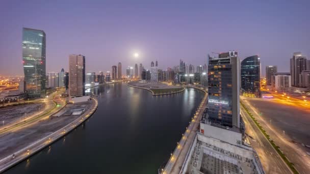 Stadsgezicht van wolkenkrabbers in Dubai Business Bay met water kanaal antenne nacht tot dag timelapse — Stockvideo