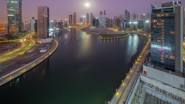 Stadsgezicht van wolkenkrabbers in Dubai Business Bay met water kanaal antenne nacht tot dag timelapse — Stockvideo