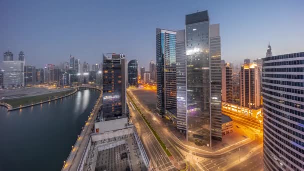 Stadsgezicht van wolkenkrabbers in Dubai Business Bay met water kanaal antenne nacht tot dag timelapse — Stockvideo