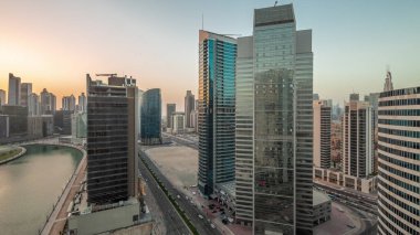 Dubai Business Bay 'deki ve şehir merkezindeki gökdelenlerin şehir manzarası. Günbegün su kanalından geceye geçiş zamanı. Günbatımından sonra kuleleri ve rıhtımı olan modern gökyüzü. Uluslararası bir iş merkezi.
