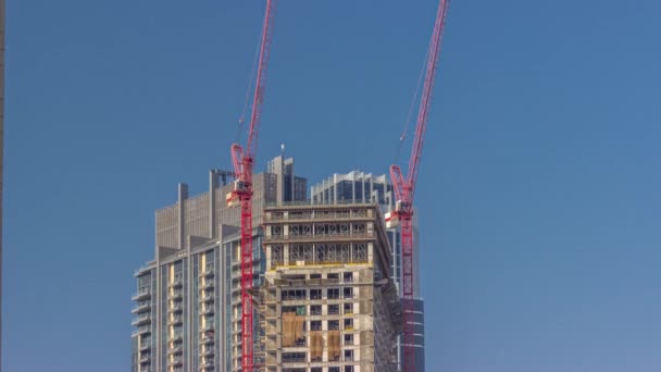 Dva jeřábi, kteří pracují na stavbě nového mrakodrapu — Stock video
