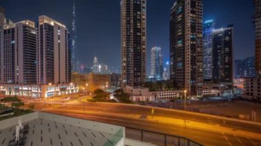 Şehir merkezindeki Dubai 'ye havadan panoramik manzara ve gece vakti gökdelenler..