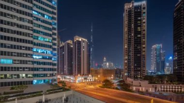 Şehir merkezindeki Dubai 'ye havadan panoramik manzara ve gece vakti gökdelenler..