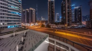 Şehir merkezindeki Dubai 'ye havadan panoramik manzara ve gece vakti gökdelenler..