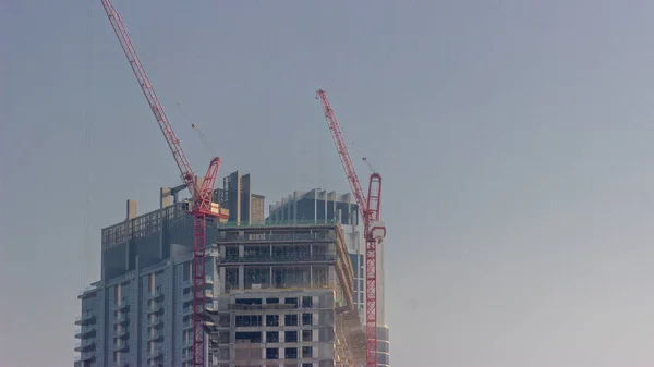 两台起重机在新摩天大楼的收缩位置上工作 高楼和晚上的建筑活动 — 图库照片