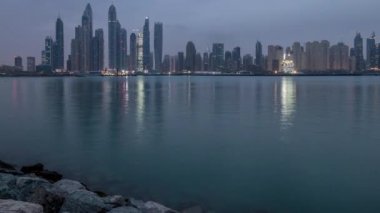 Gün timelapse Dubai şehir gece Palm Jumeirah Adası'içinde modern gökdelenler Panoraması.
