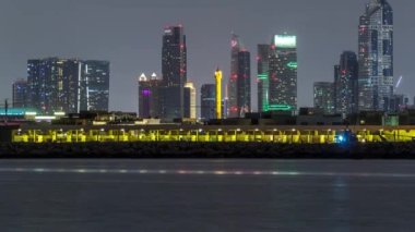 Modern Dubai şehir manzarası timelapse su yüzeyi üzerinde ışıklandırılmış gökdelenler ile gece
