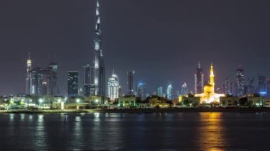 Modern Dubai şehir manzarası timelapse su yüzeyi üzerinde ışıklandırılmış gökdelenler ile gece