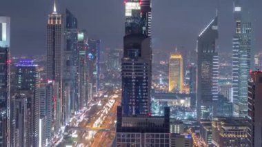 Doğal Dubai şehir manzarası, gece timelapse. Şeyh Zayed caddesi üzerinde çok sayıda ışıklı Kuleli çatı görünümü.