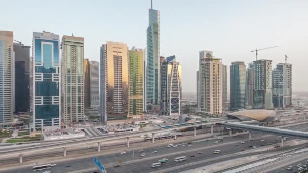 Flygfoto över Jumeirah lakes towers skyskrapor dag till natt timelapse med trafik på sheikh zayed road. — Stockvideo