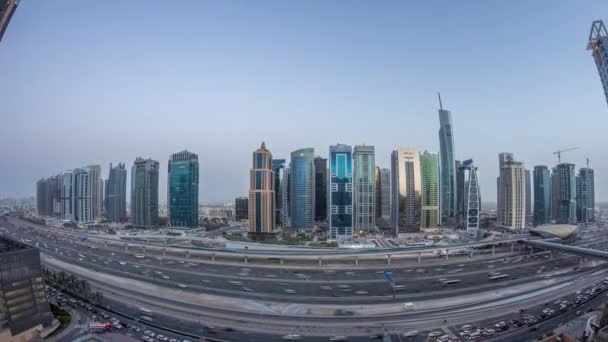 Flygfoto över Jumeirah lakes towers skyskrapor dag till natt timelapse med trafik på sheikh zayed road. — Stockvideo