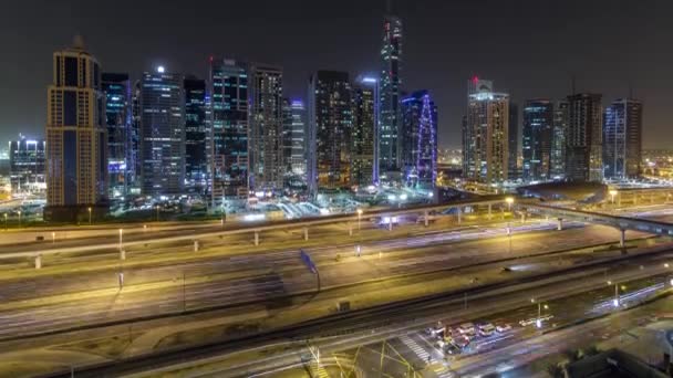 Luchtfoto van Jumeirah lakes towers wolkenkrabbers nacht timelapse met verkeer aan sheikh zayed road. — Stockvideo