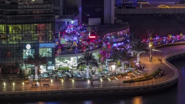 Promenade en kanaal in Dubai Marina met luxe wolkenkrabbers en jachten rond nacht timelapse, Verenigde Arabische Emiraten — Stockvideo