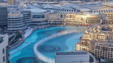 Havadan görünümü dans çeşmeler akşam şehir merkezine ve Dubai, BAE insan yapımı bir göl timelapse.