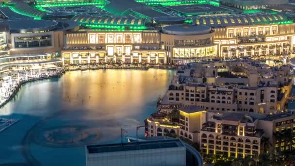 Vista aérea nocturna Fuentes de baile en el centro y en un timelapse lago artificial en Dubai, Emiratos Árabes Unidos . — Vídeos de Stock