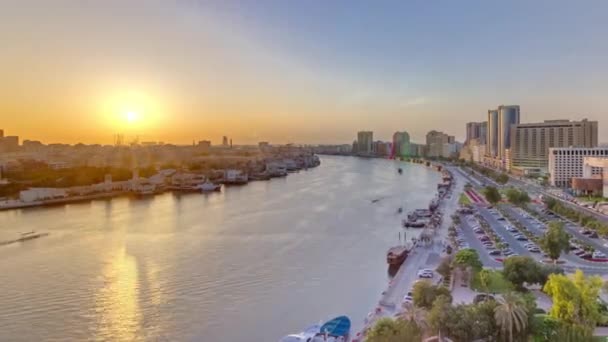 Dubai creek pejzaż o zachodzie słońca timelapse z łodzi i statków w pobliżu nabrzeża — Wideo stockowe