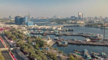 Dubai creek manzara timelapse tekneler ve gemi limanda ve gün batımı sırasında arka planda modern binalar